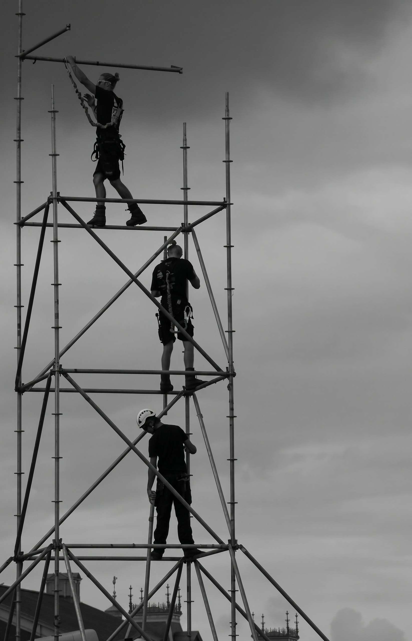 Torre de andaime com trabalhadores, em preto e branco