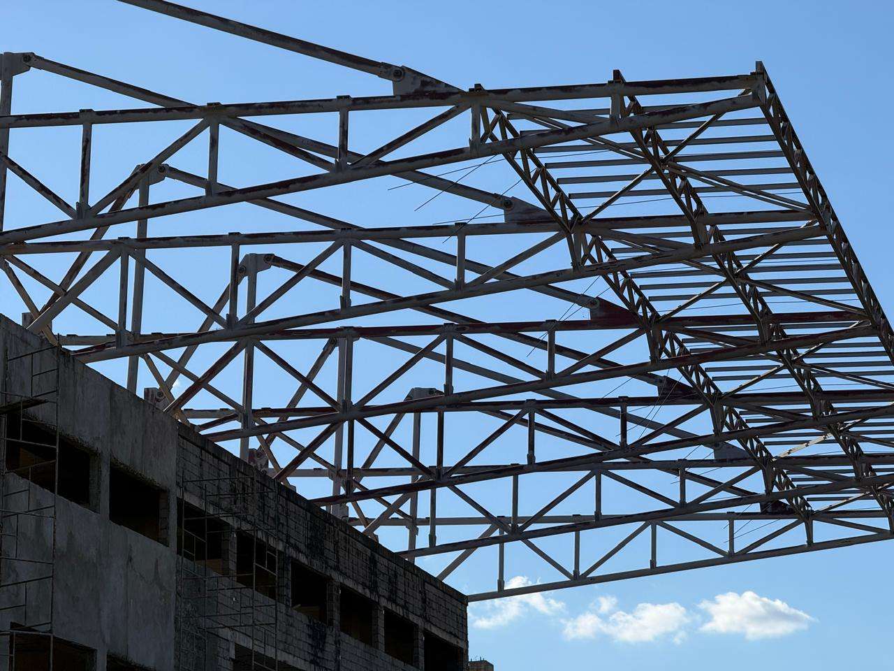 Treliças de uma cobertura metálica montadas sobre uma edificação