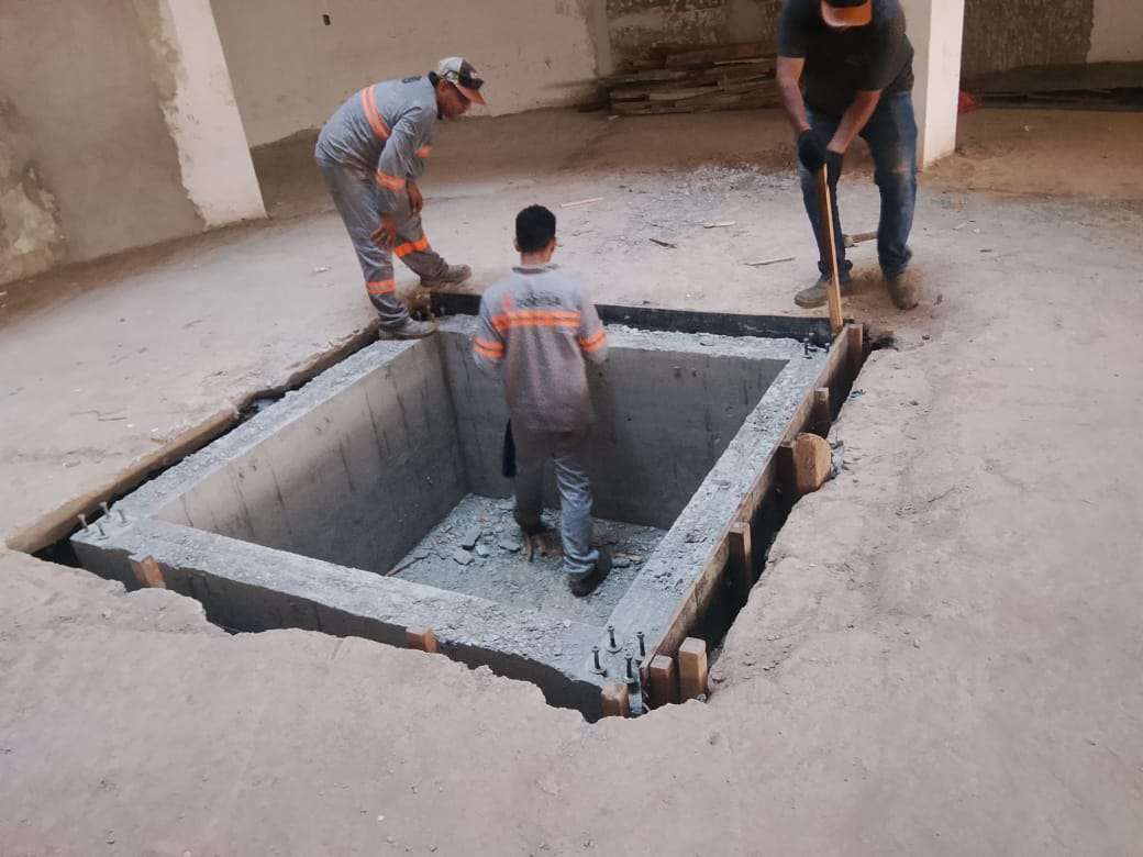Equipe trabalhando na execução de uma base retangular em concreto