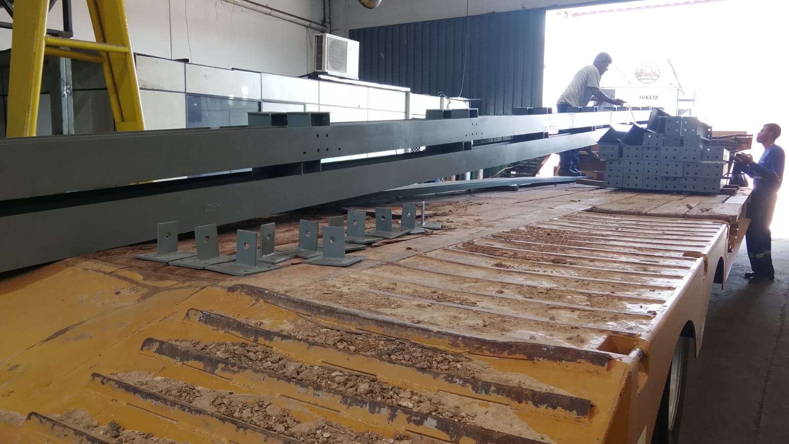 Perfis metálicos fabricados e organizados sobre uma carreta para transporte