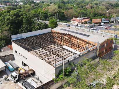 Vista aérea de obra com fundações, paredes e estrutura de cobertura